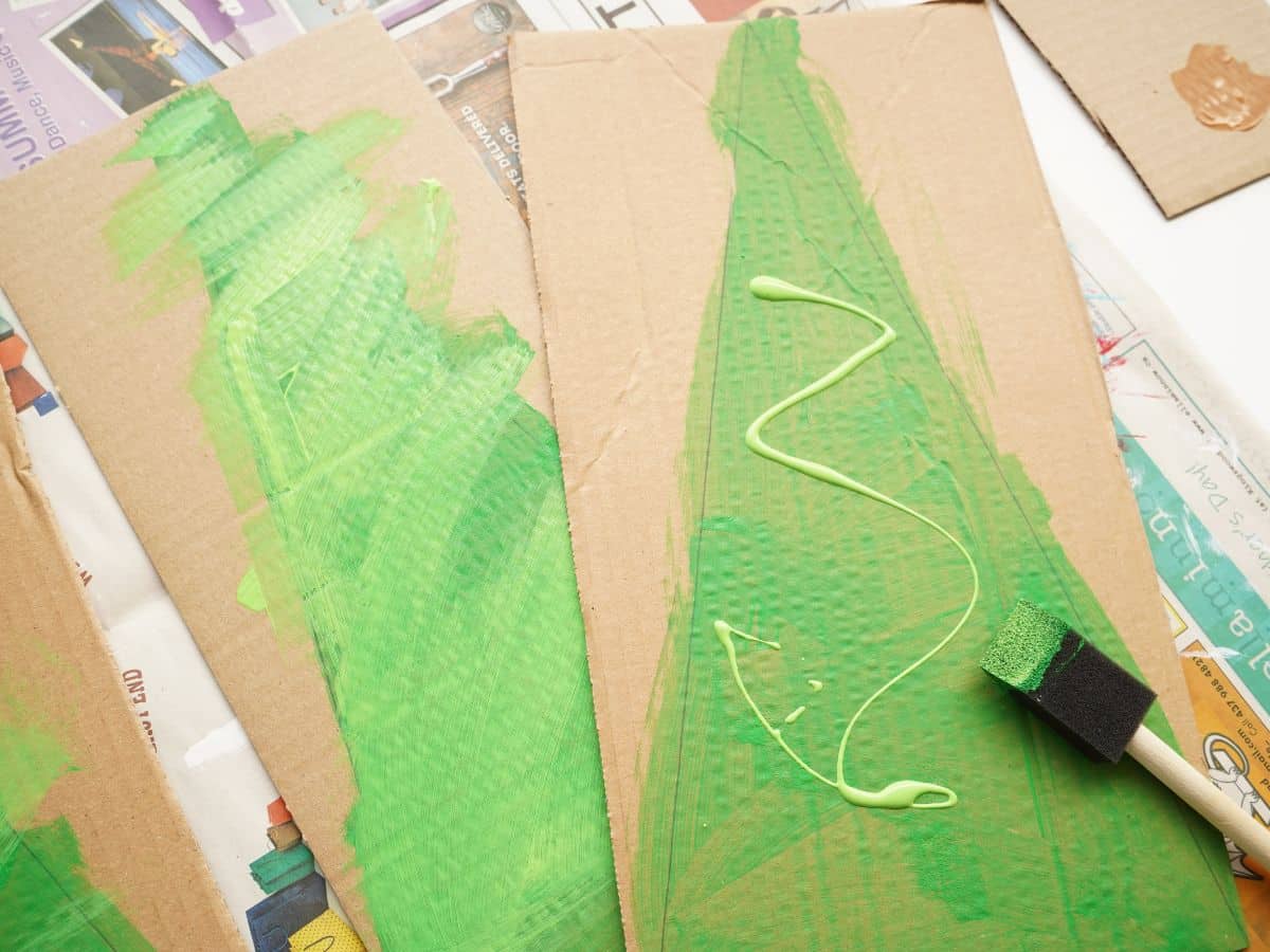 cardboard christmas trees painted in green with foam paint brush