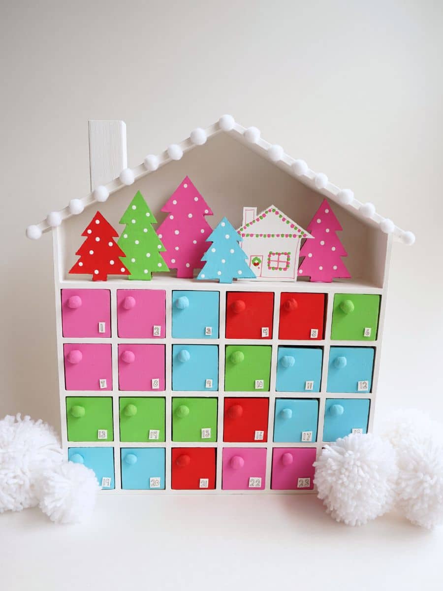 finished diy wooden advent calendar surrounded by white pom poms