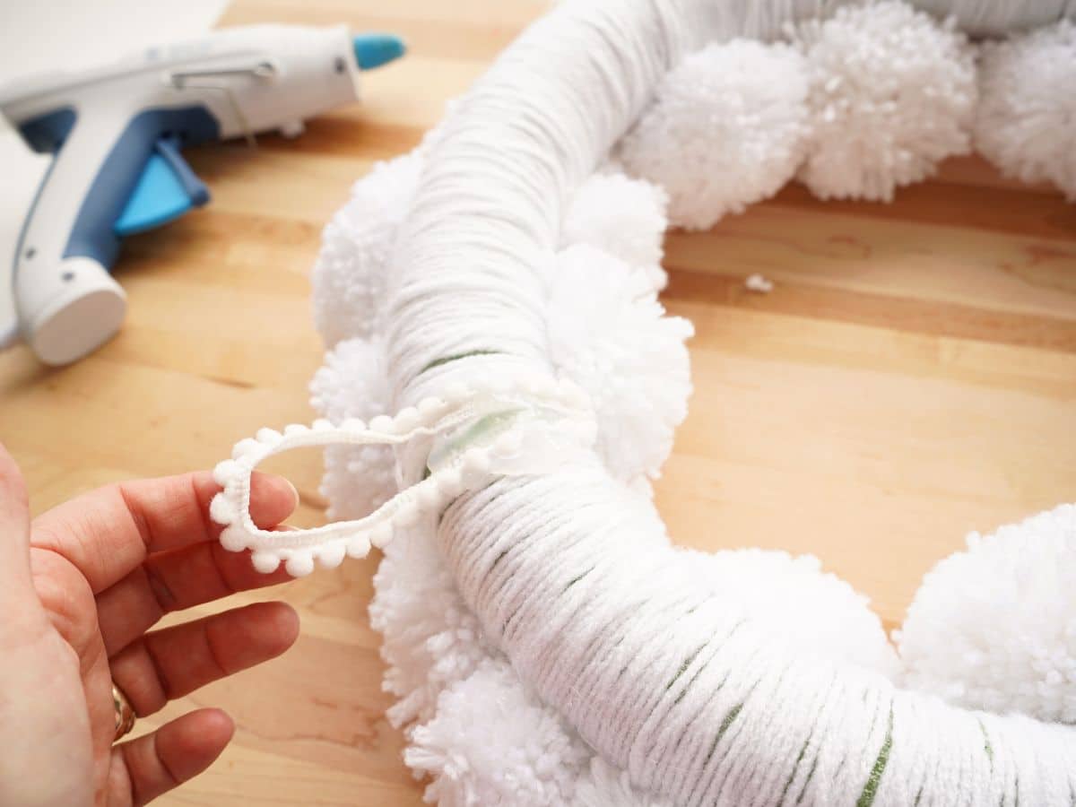 close up of loop of ribbon glued on top of pompom wreath