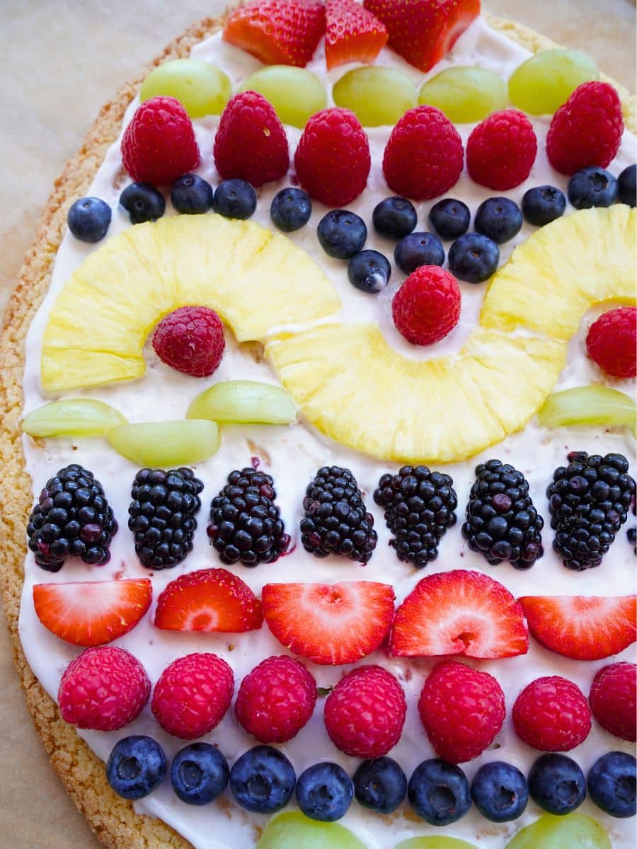 close up of easter egg cookie pizza with fruit and strawberry spread