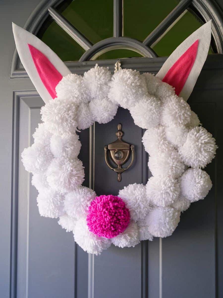 easter bunny pom pom wreath hanging on front door