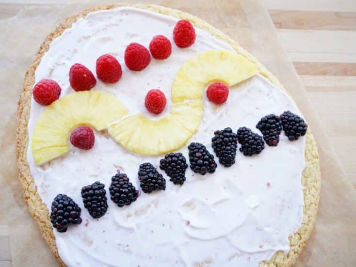 pineapple slices and blackberries decorating easter egg fruit pizza