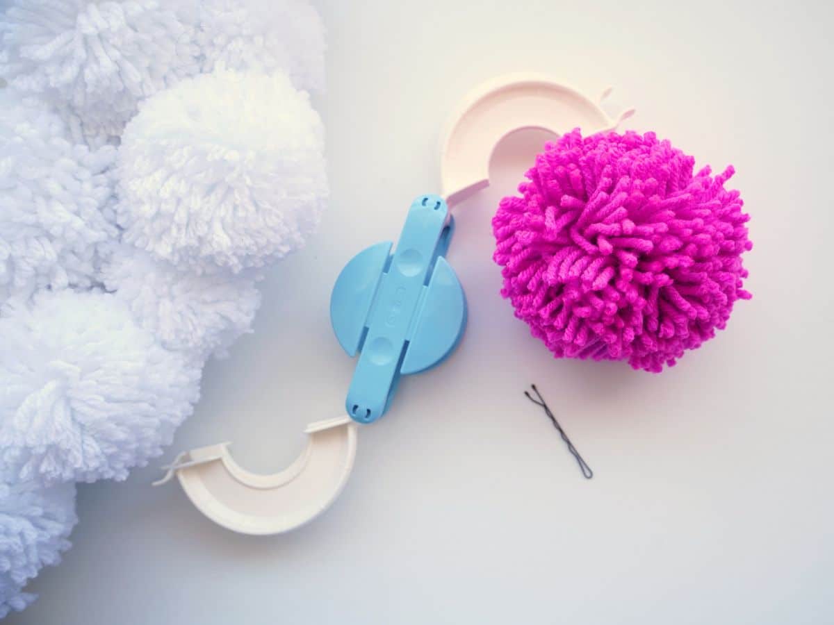 pom pom maker with pink pom pom and bobby pin