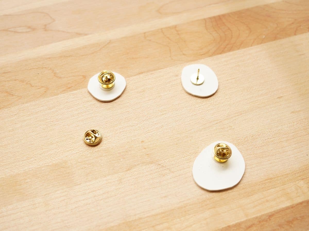 pin backers being glue to back of homemade Earth Day pins