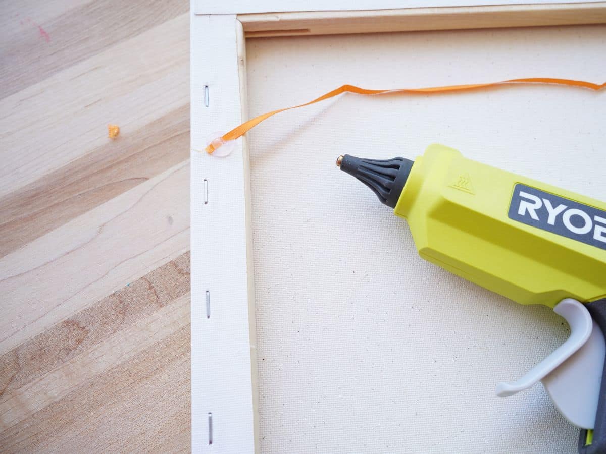 orange ribbon glued on back of canvas with ryobi cordless glue gun