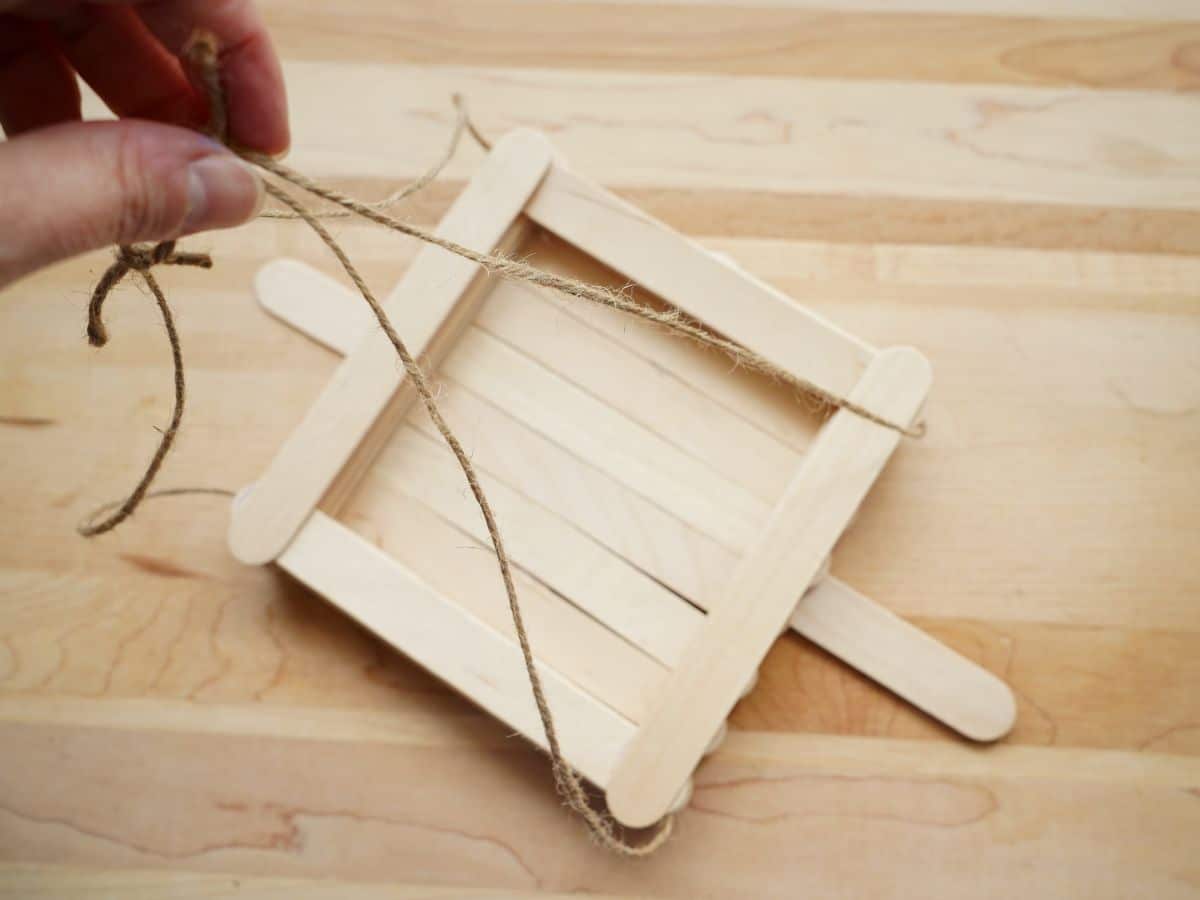 hanging popsicle stick bird feeder done and in person's hand and