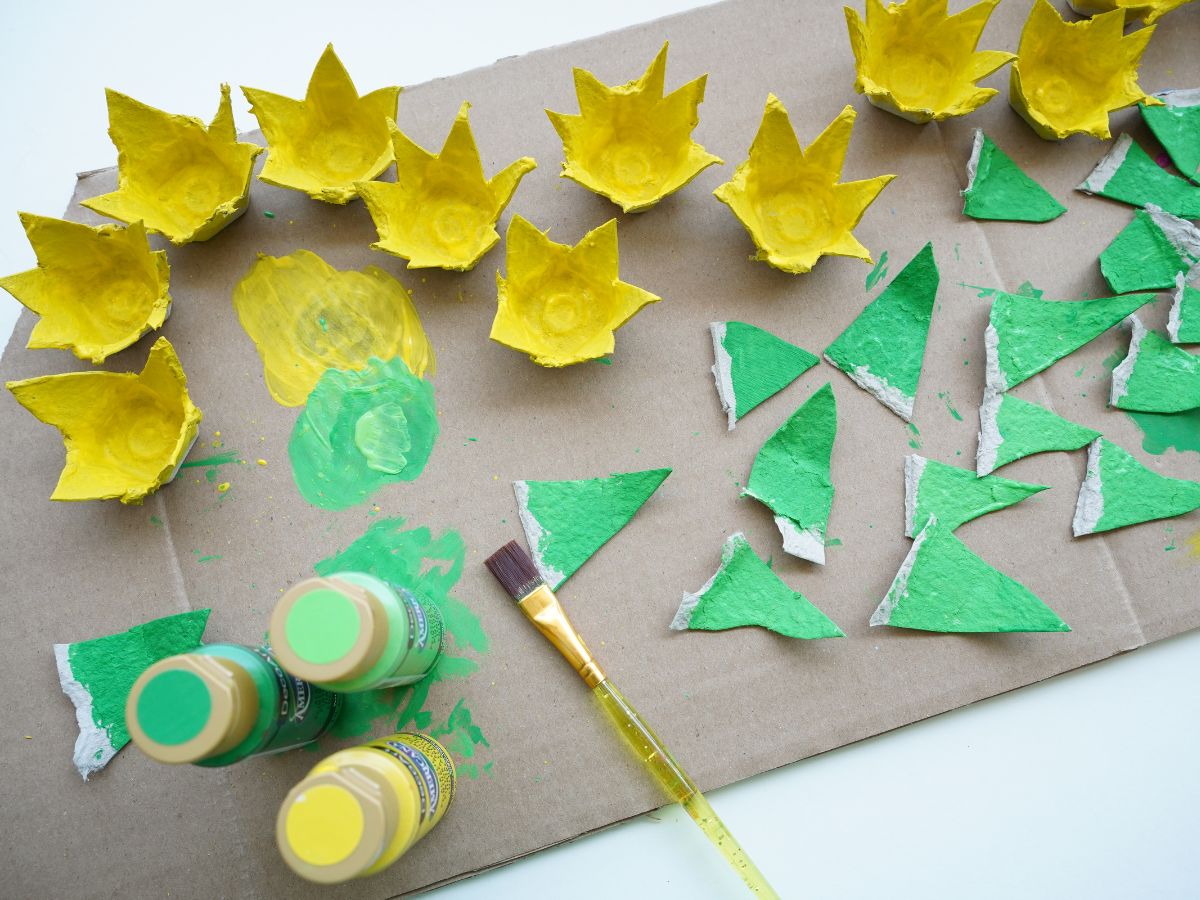 egg carton flowers painted yellow with egg carton leaves painted green and paint brush