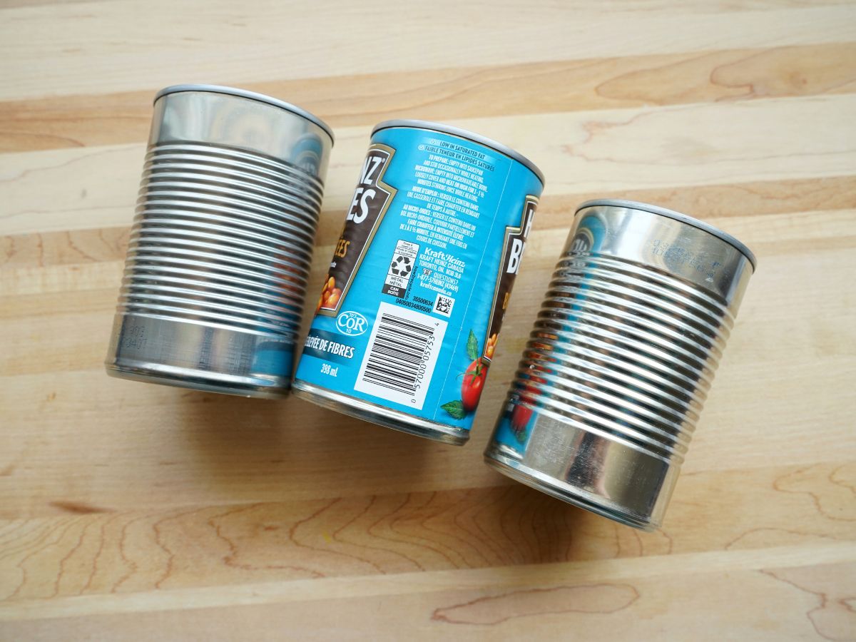2 tin cans peeled and 1 can with cover on it still