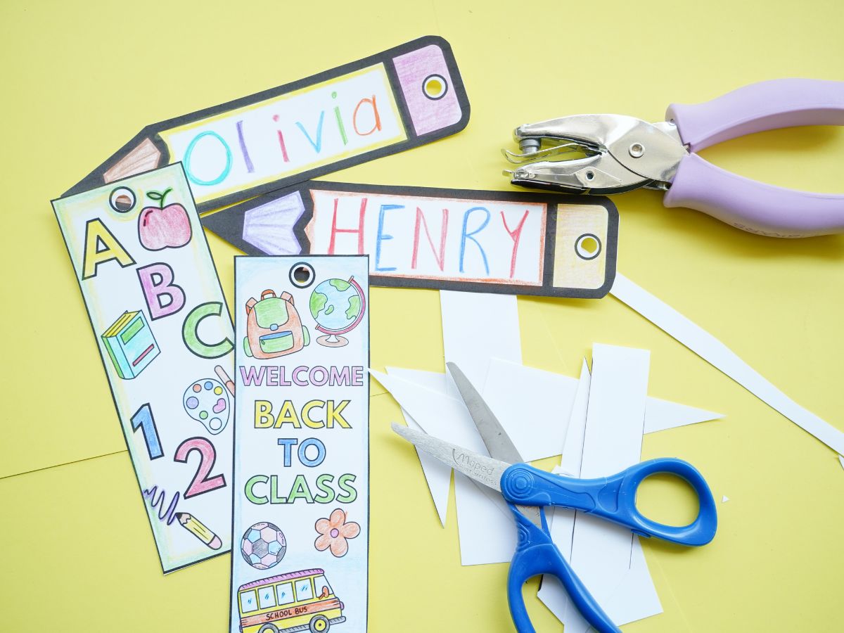 4 back to school bookmarks colored with single hole punch and pair of scissors on table