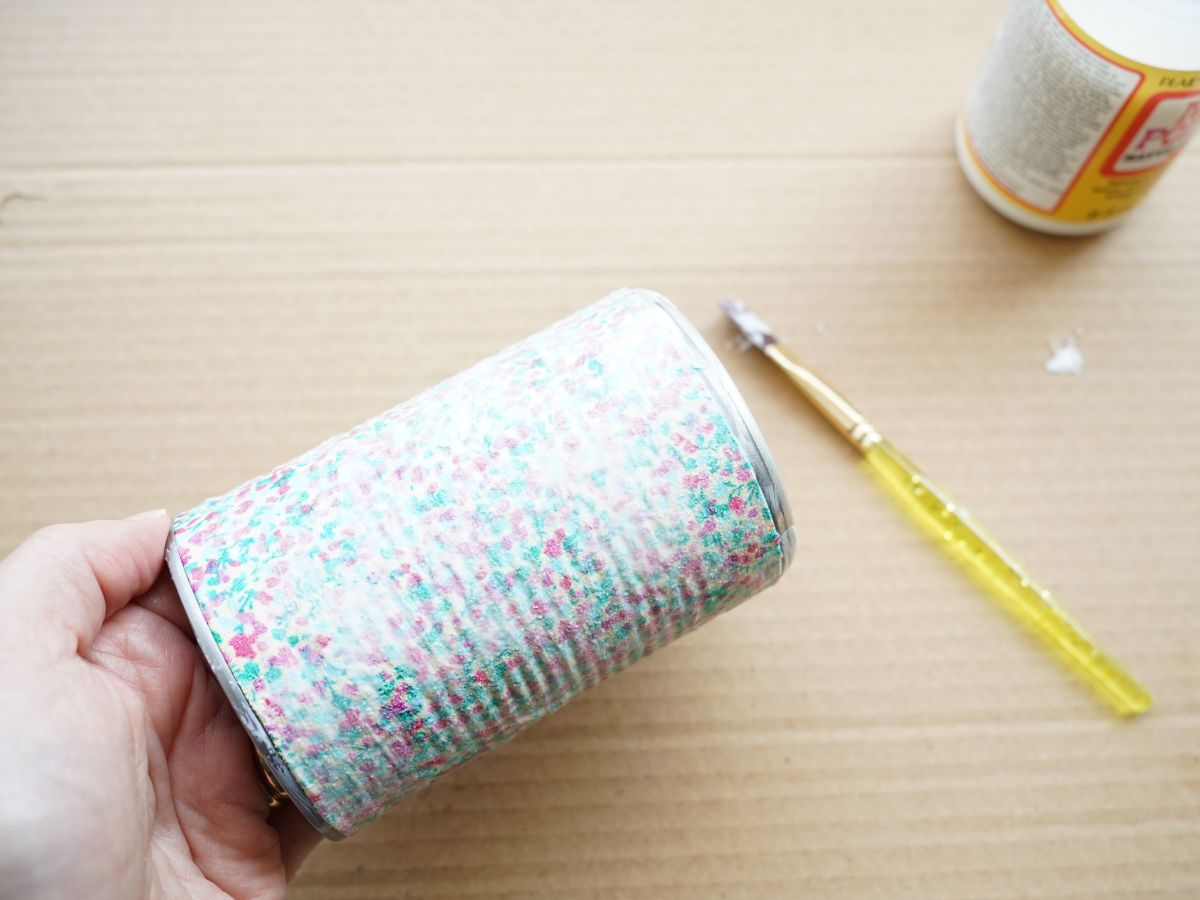 fabric covered pencil cup coated in mod podge with paintbrush