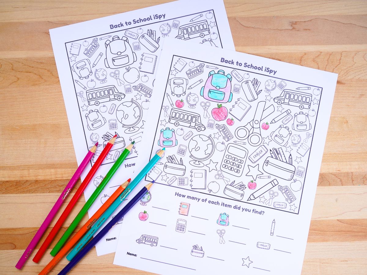 image of 2 sheets of back to school ispy game one is colored in and has a pile of pencil crayons on top