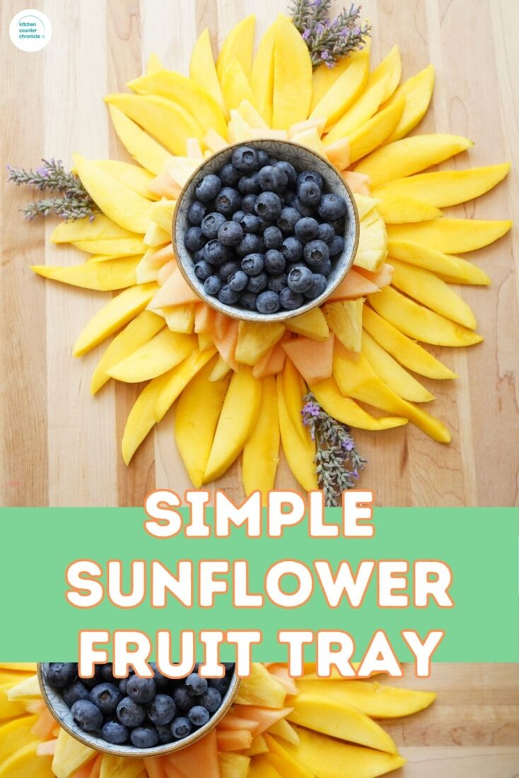 simple sunflower fruit tray with sunflower fruit tray made with mango slices, pineapple and cantaloupe with bowl of blueberries in middle and sprigs of lavender
