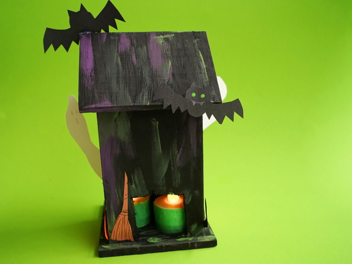 back of diy haunted house craft with hole in wall and battery-powered tea lights inside