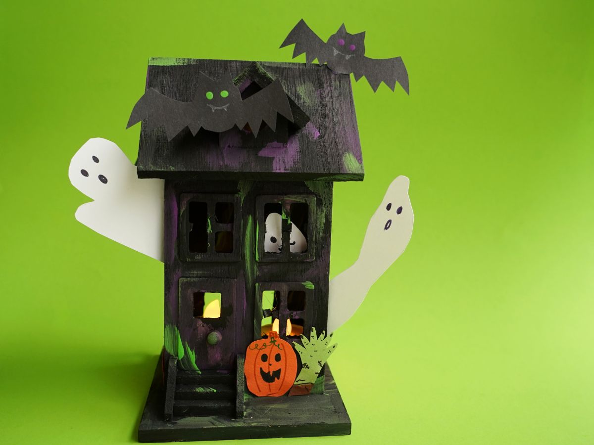 close up of construction paper bats on haunted house and ghost inside haunted house window