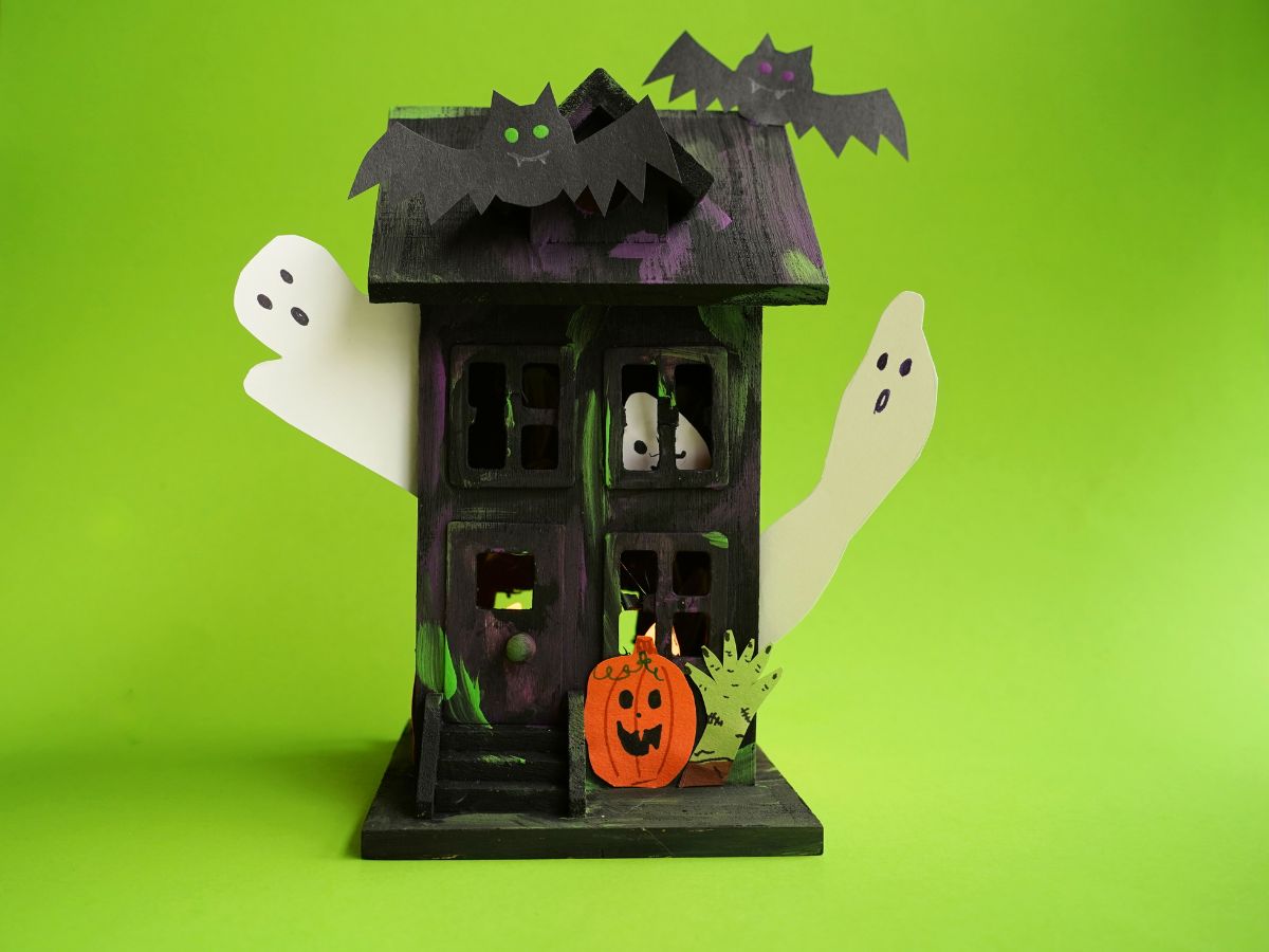 finished painted wooden haunted house craft with ghosts and bats and pumpkins