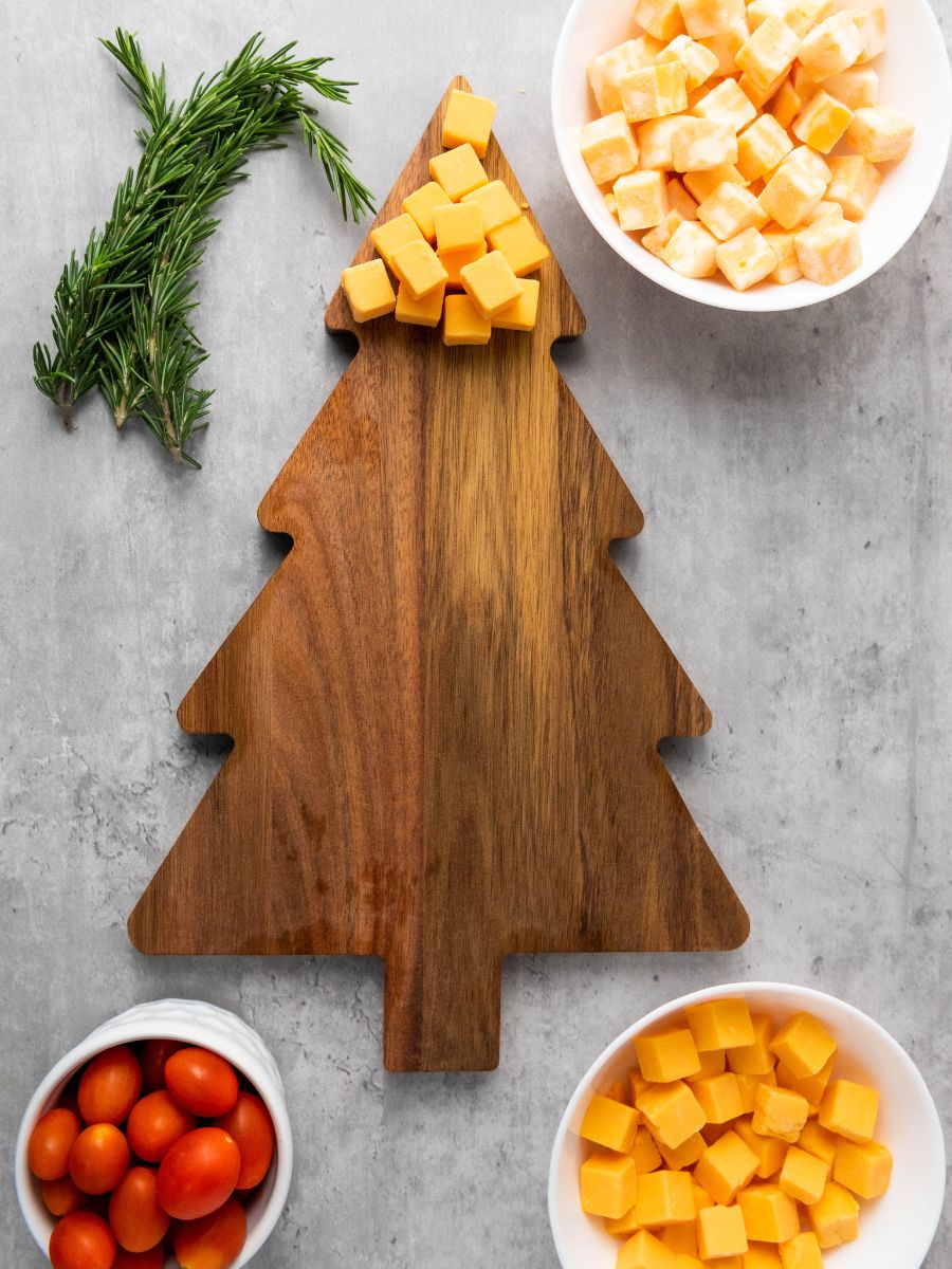 gouda cheese squares on top of christmas tree shaped cutting board
