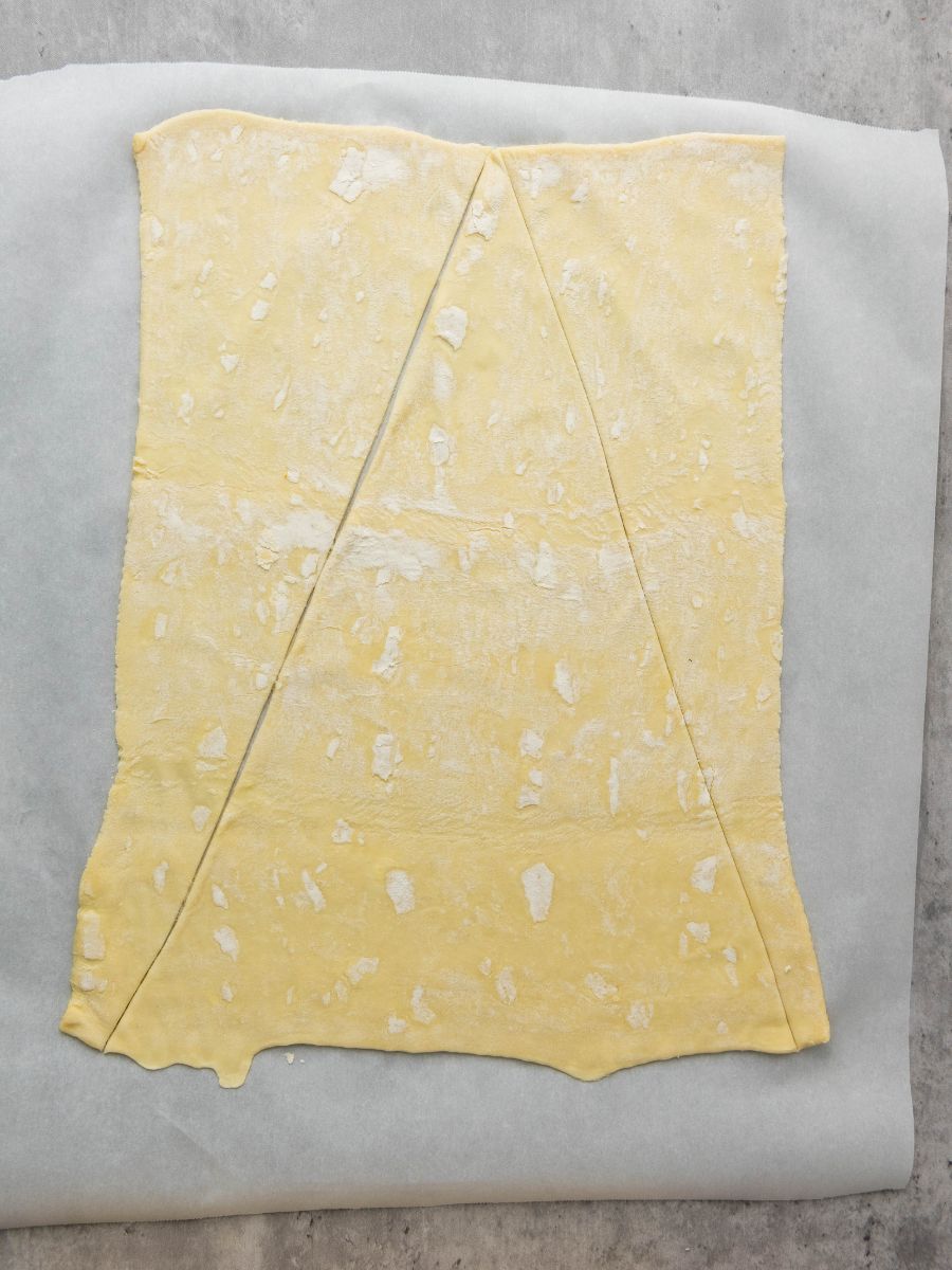 sheet of parchment paper with sheet of puff pastry on it