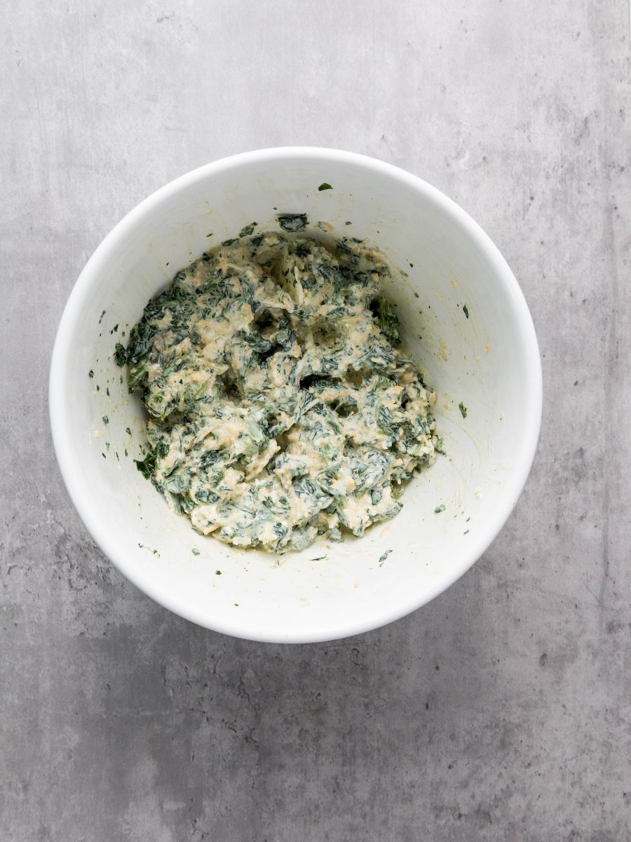 spinach dip mixed in a white bowl