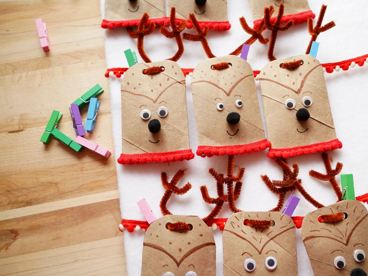 toilet paper reindeer advent calendar boxes being clothes pinned to ribbon on board