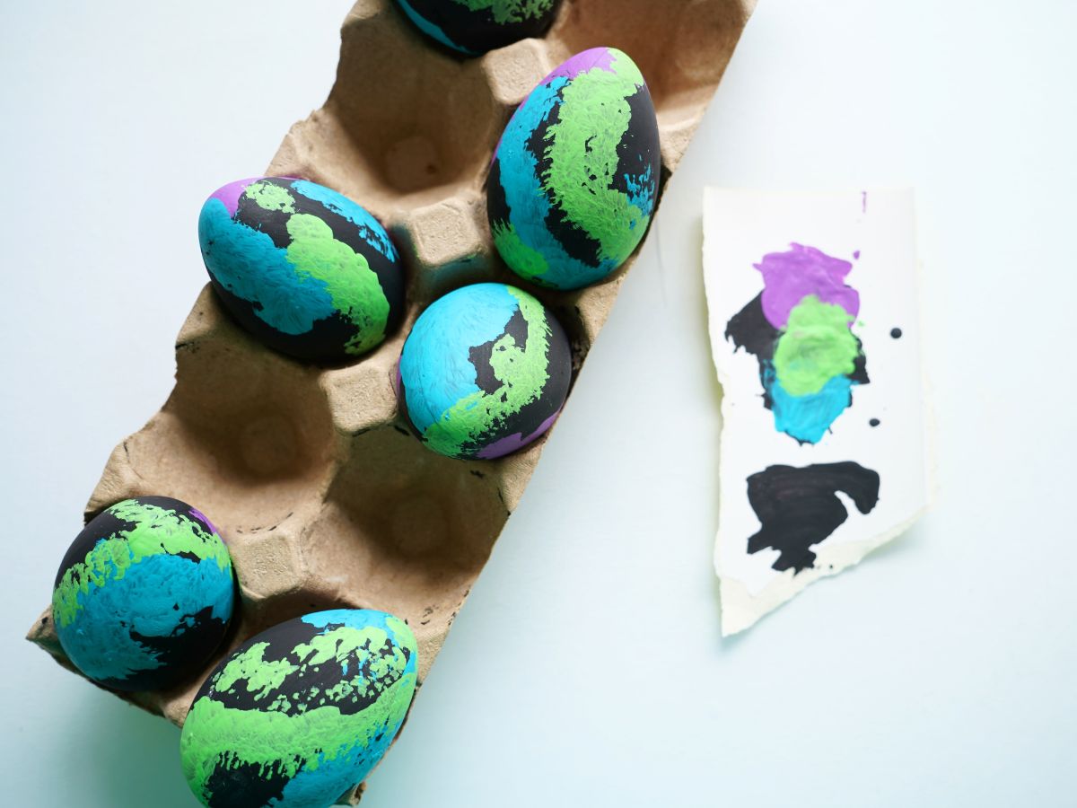 black easter eggs painted with green, purple and blue