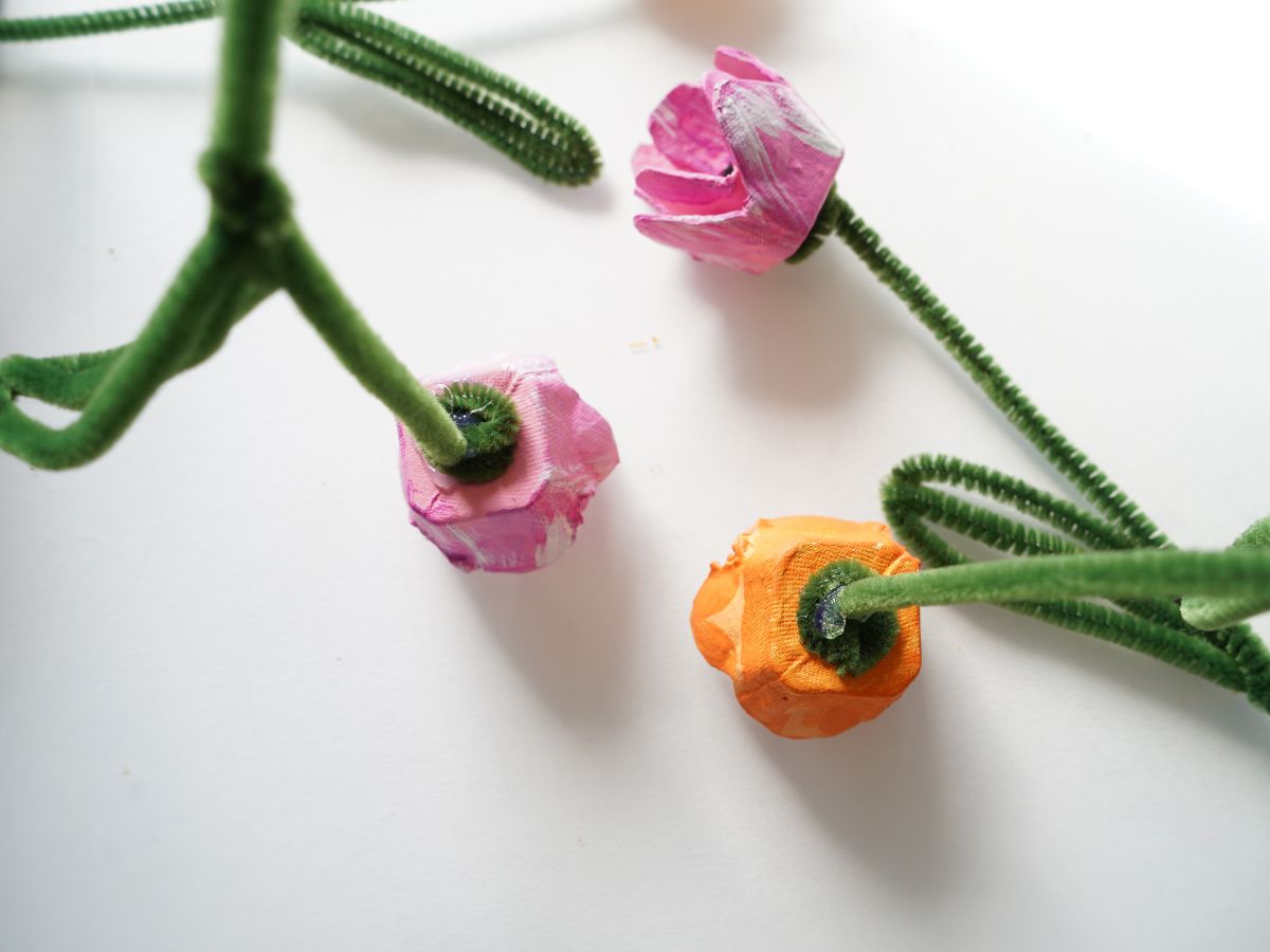 close up of egg carton tulip head being glued to pipe cleaner stem