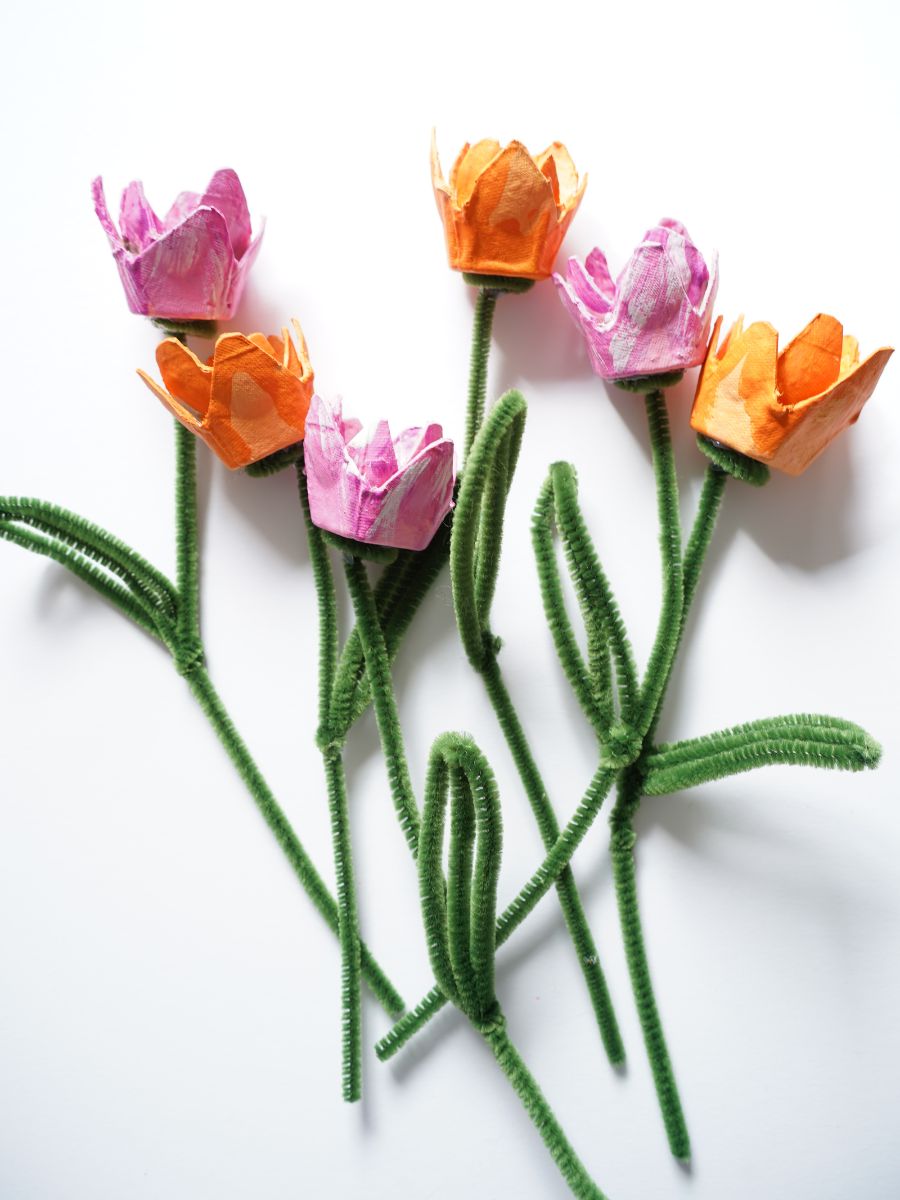 pile of egg carton tulips with pipe cleaner stems laying on side