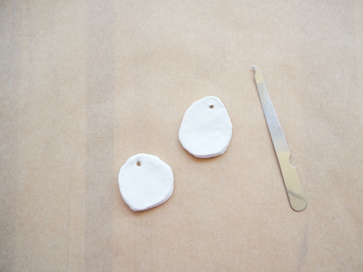 circle of air dry clay charm dried and sanded edges with metal file