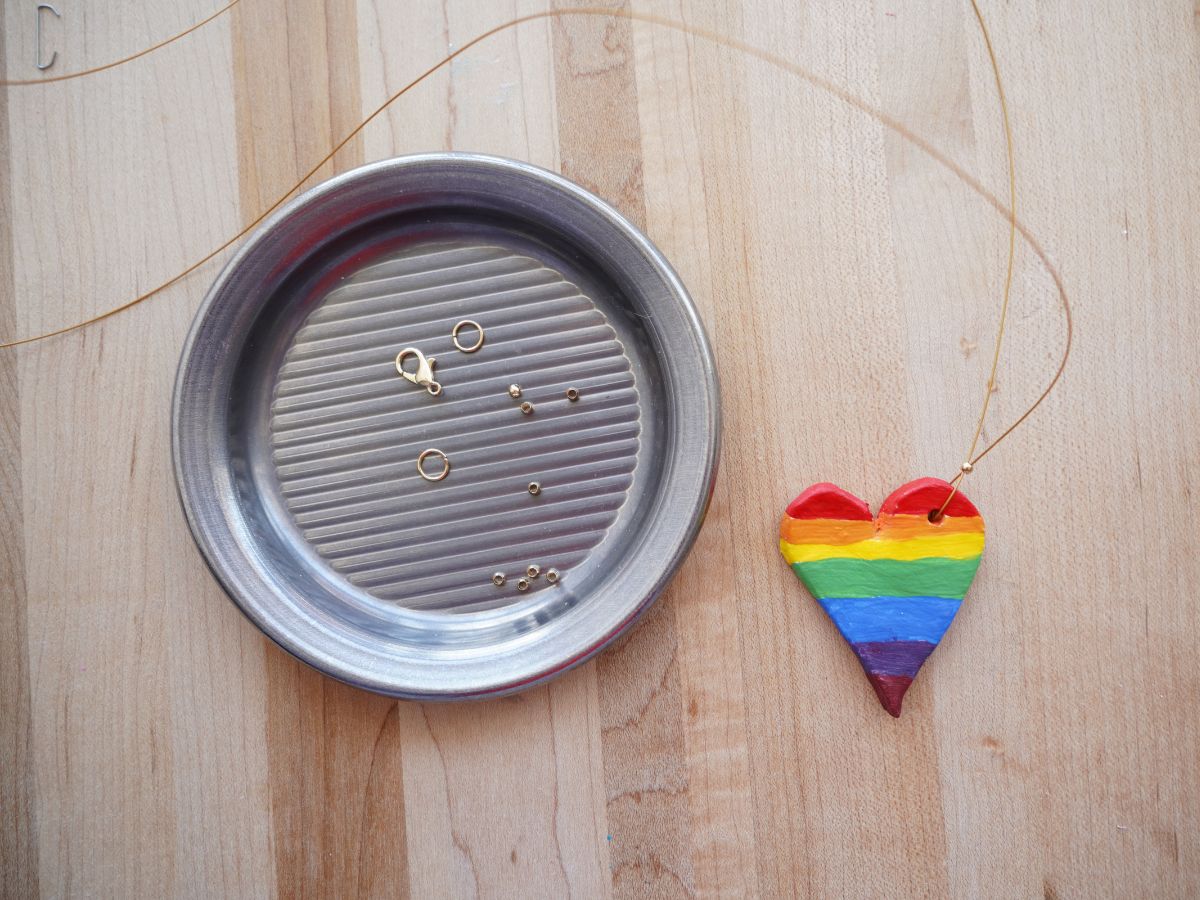 crimp beads and clasp and jump loops in dish and rainbow heart pendant on metal thread with crimp bead
