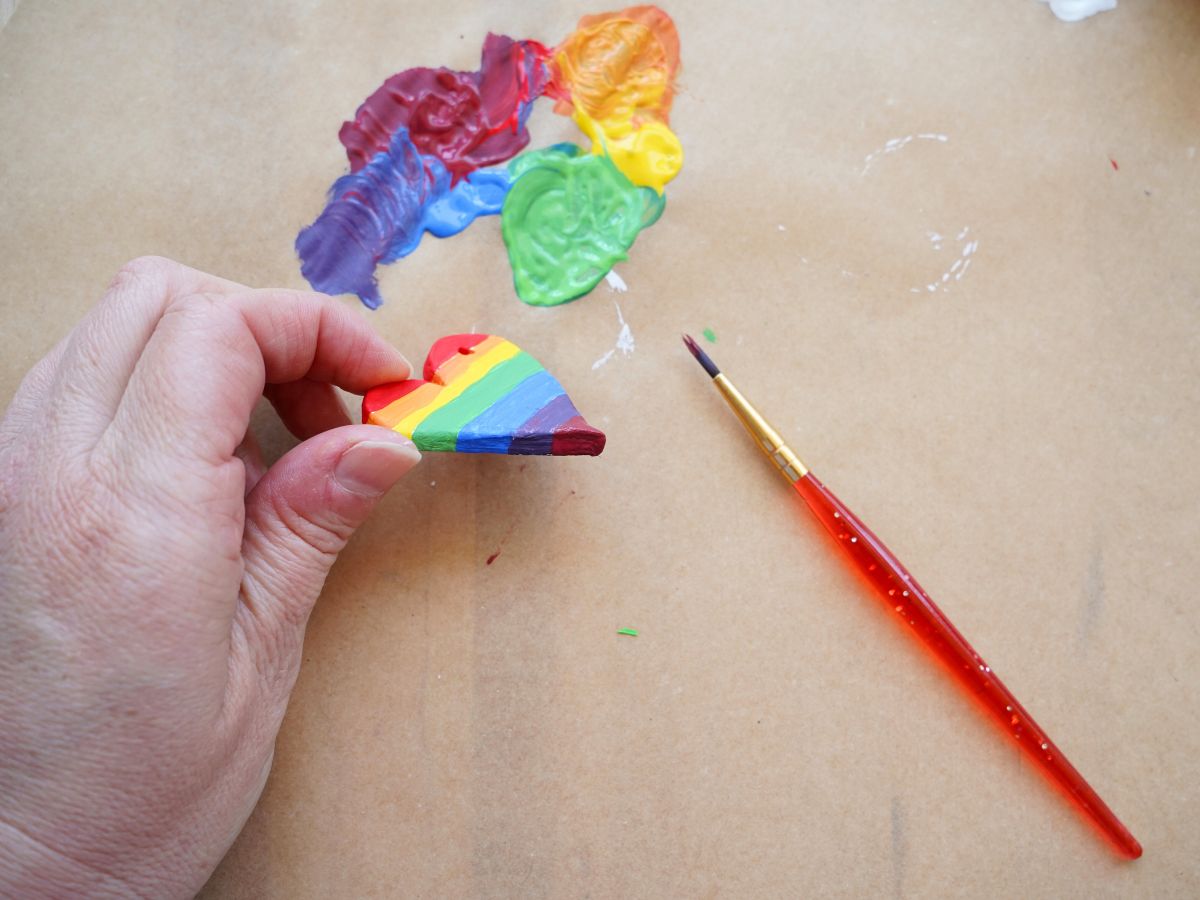 rainbow stripes on sides of clay heart with paintbrush