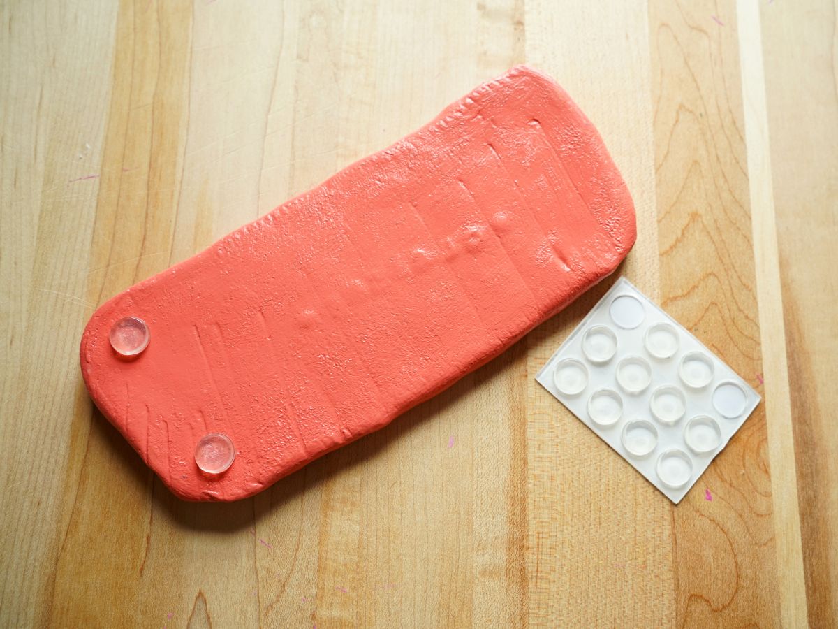 underside of glasses tray with peel and stick feet being added