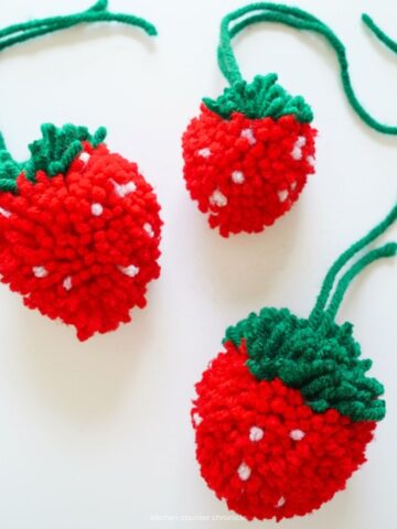 3 pom pom strawberries on white background