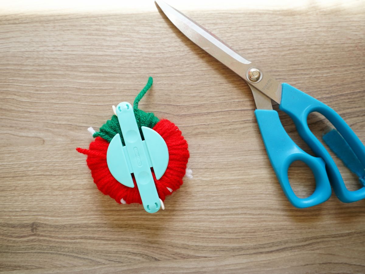 pom pom maker closed and fully wrapped with yarn for strawberry