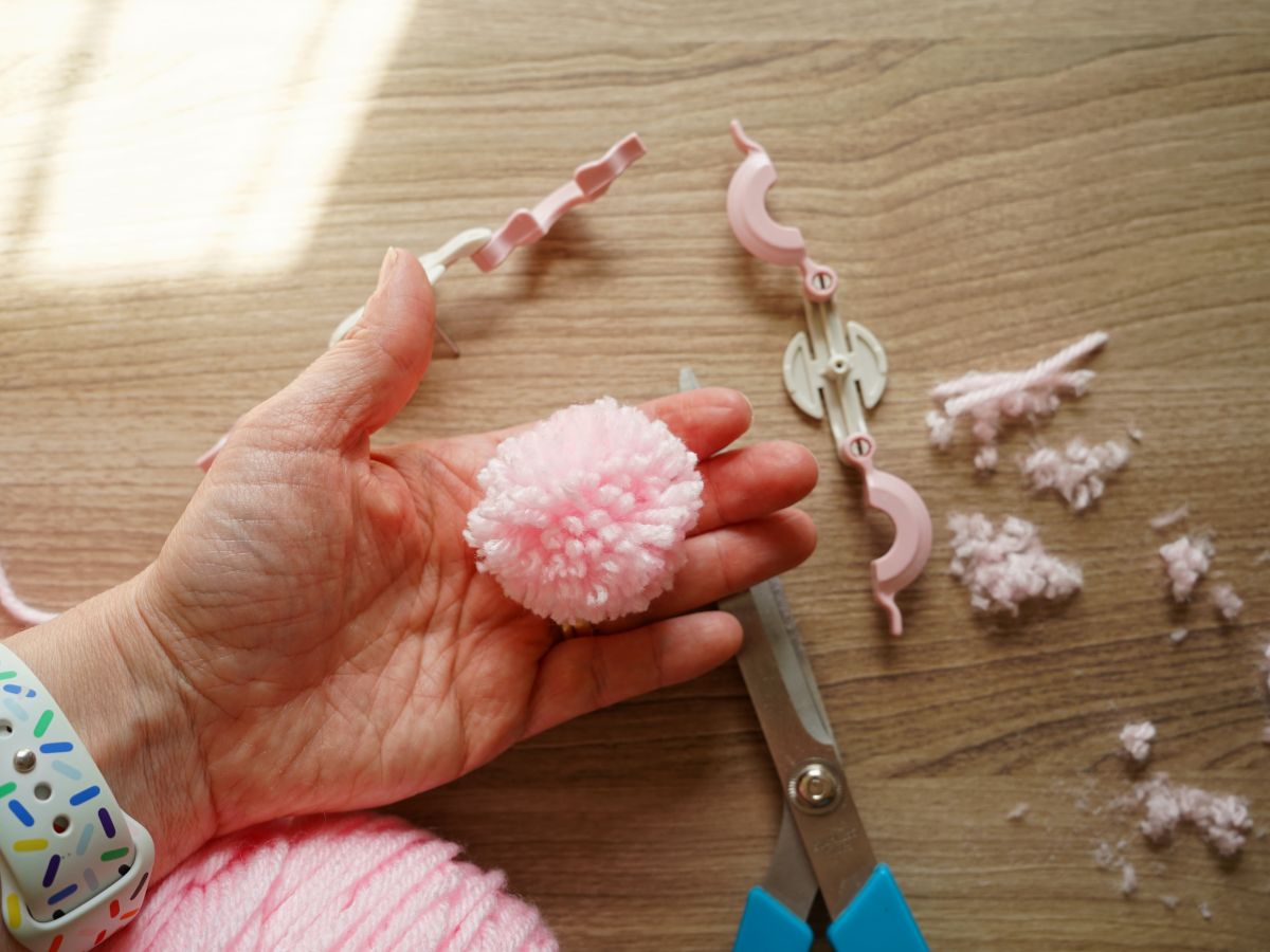 strawberry ice cream pink pompom in woman's hand
