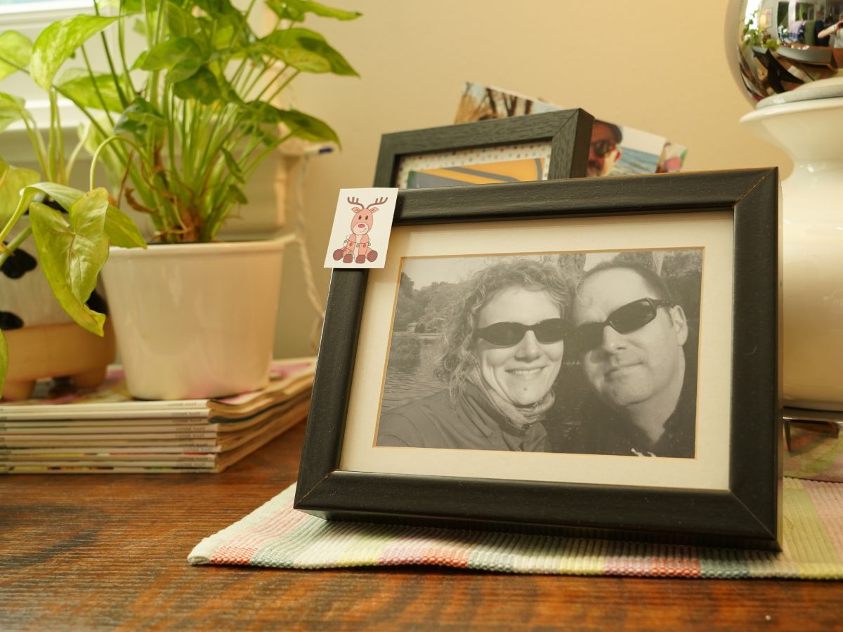 little santa's reindeer taped to picture frame of couple