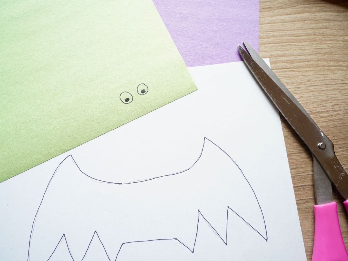bat wings and bat eyes drawn on construction paper with pair of scissors