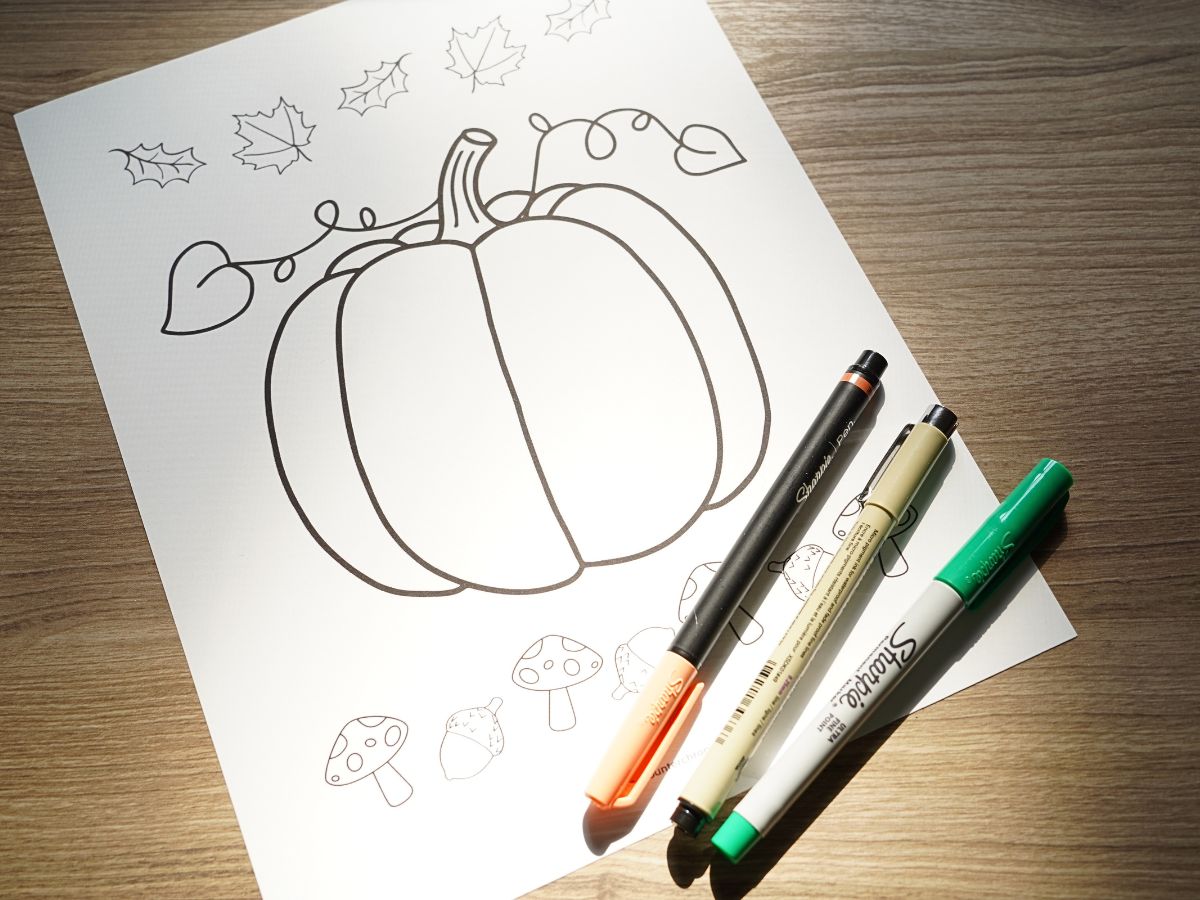 blank printable pumpkin zentangle coloring page with a pile of pens