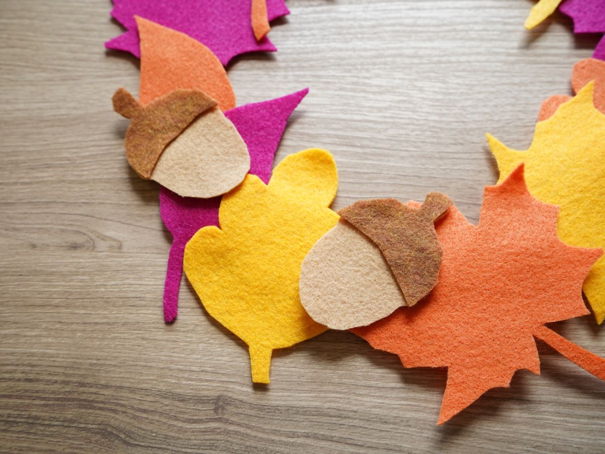 close up of colorful felt leaves and felt acorns on wreath