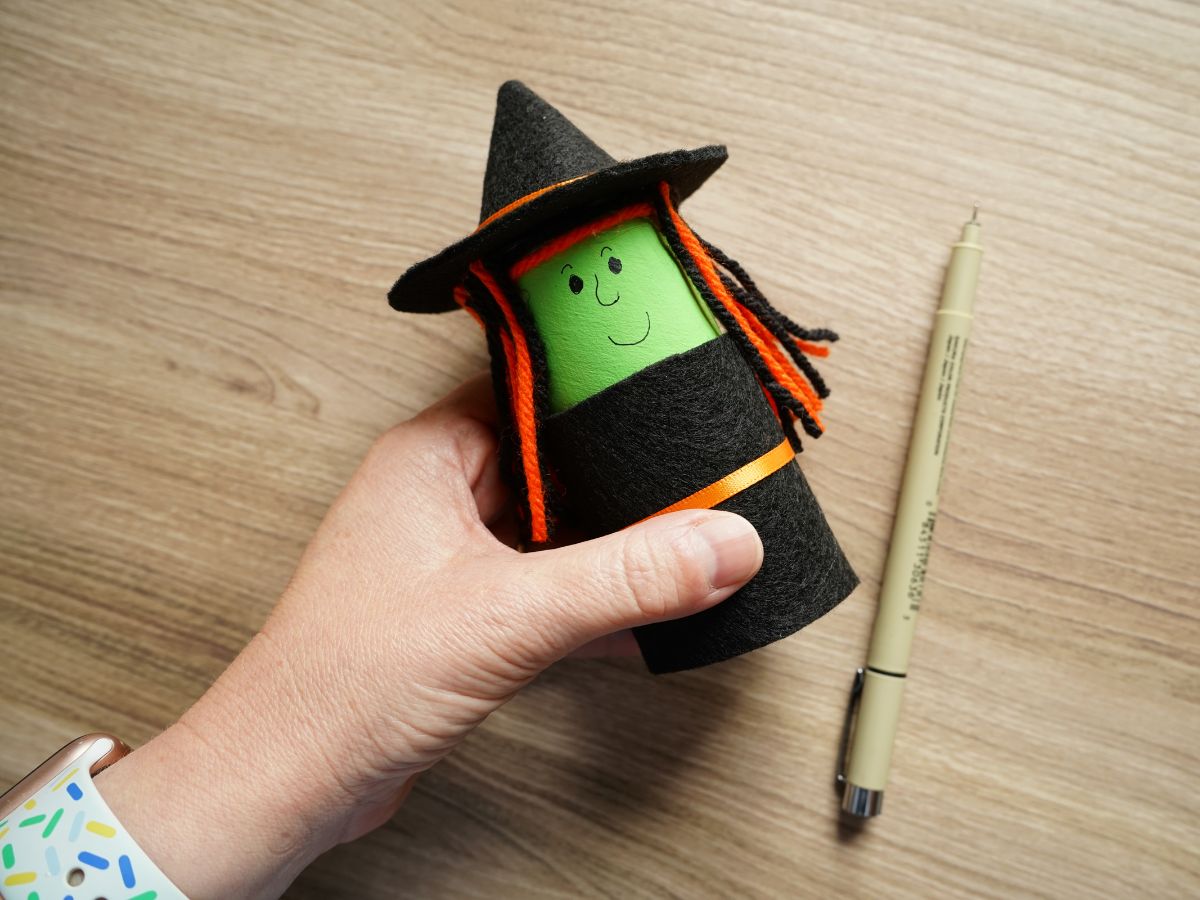 face of witch being drawn on toilet roll witch with black pen
