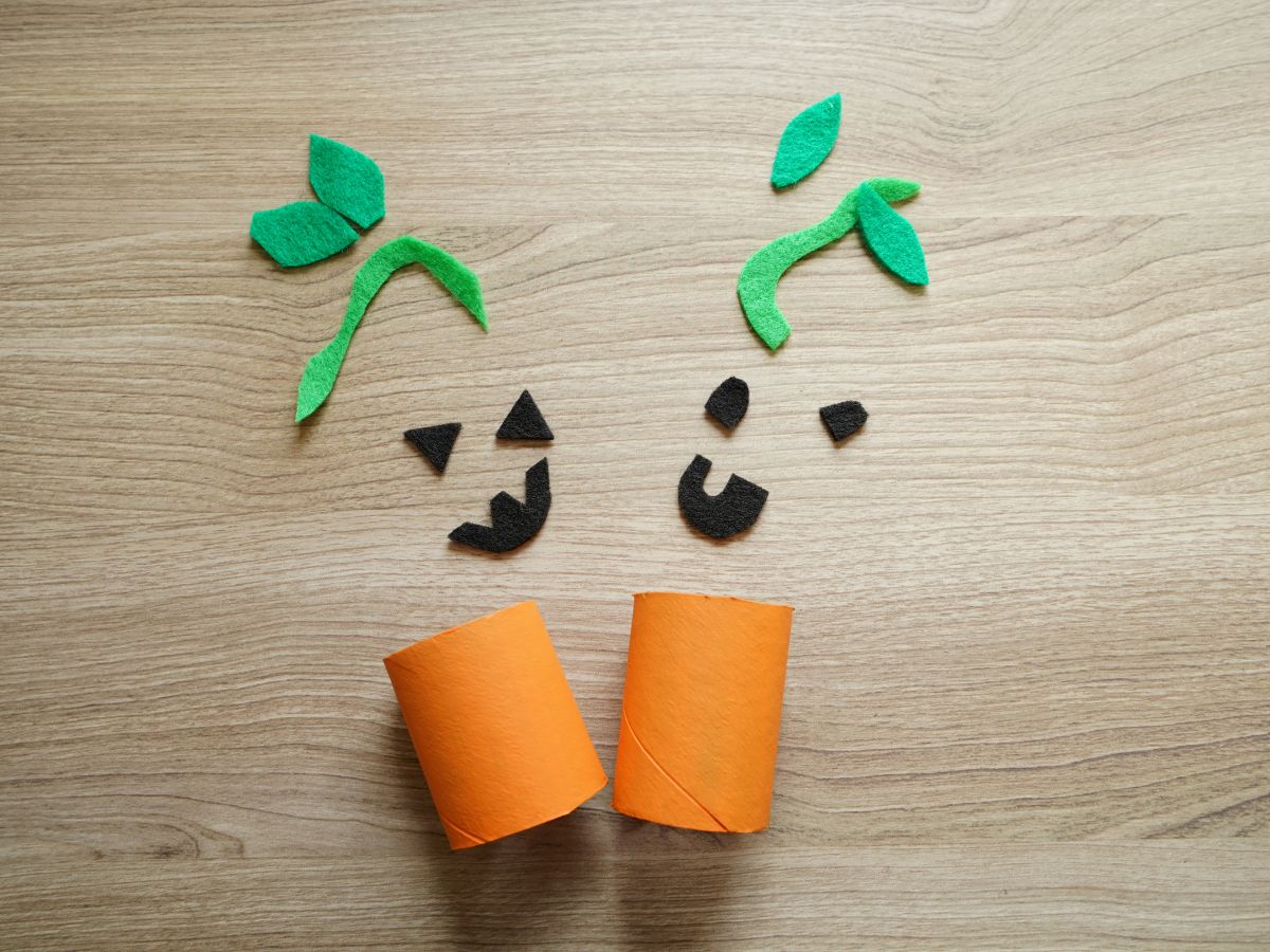 felt pumpkin faces and toilet roll pumpkins on table