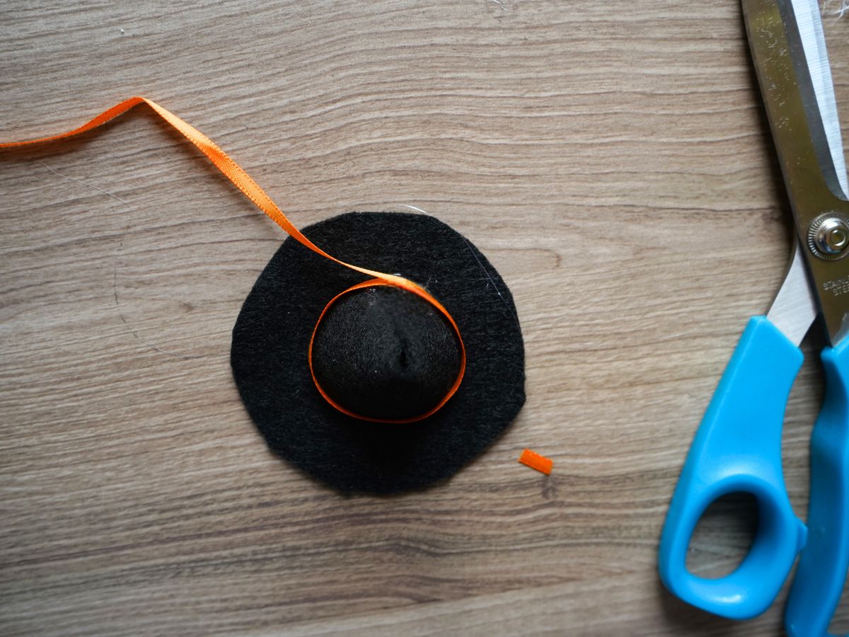 felt witch hat with orange ribbon wrapped and glued around it