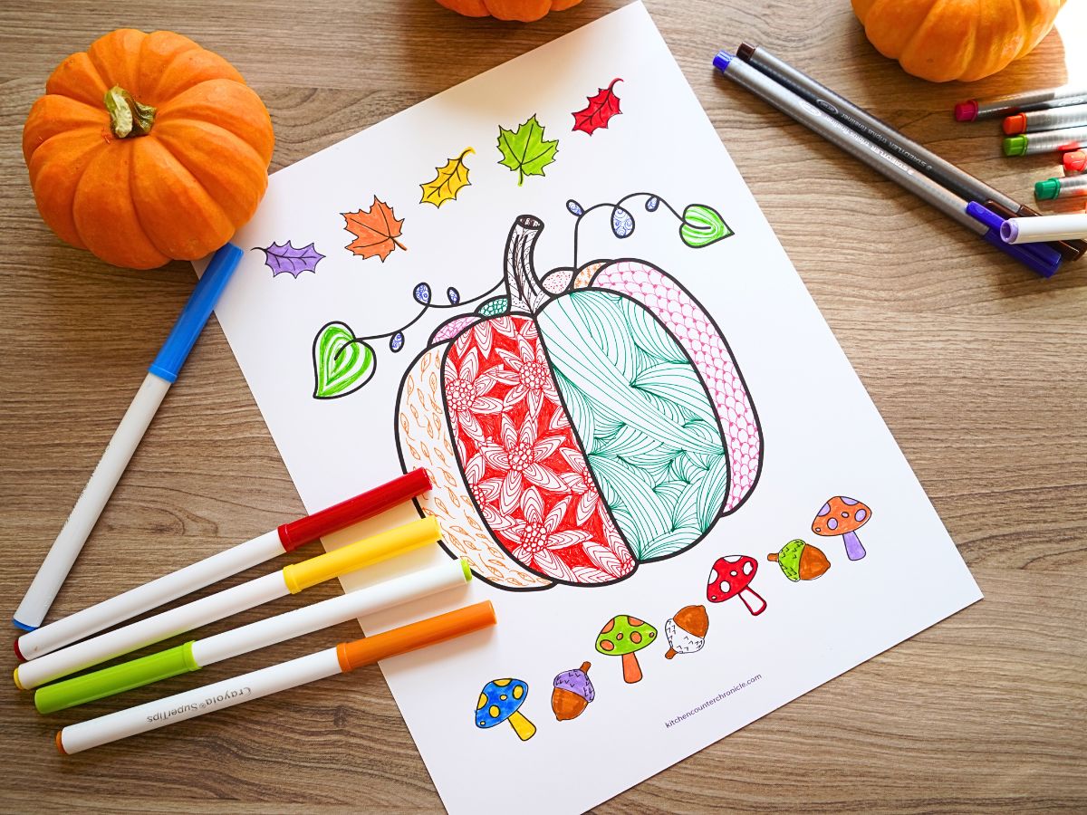 little pumpkins surrounding our printable fall pumpkin zentangle coloring page with a pile of markers