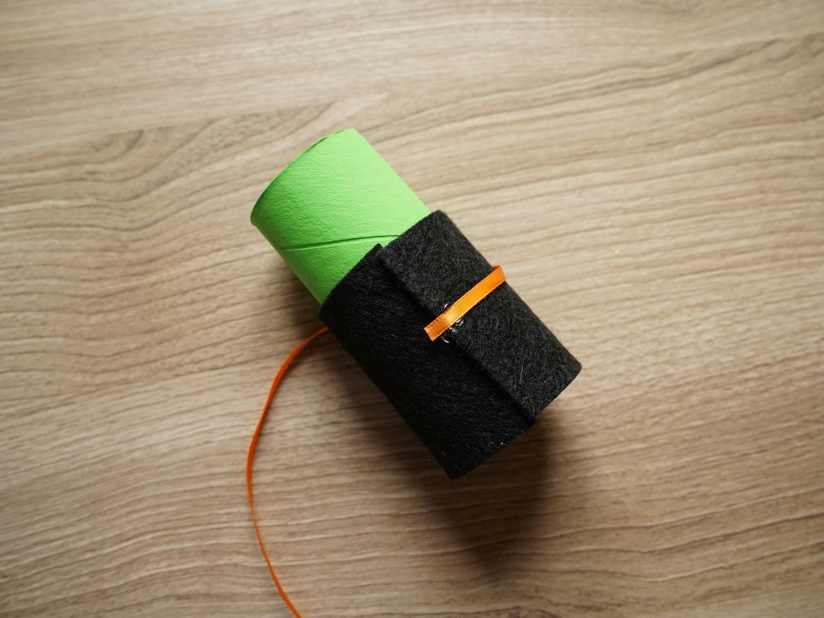orange ribbon belt glued around toilet roll witch waist