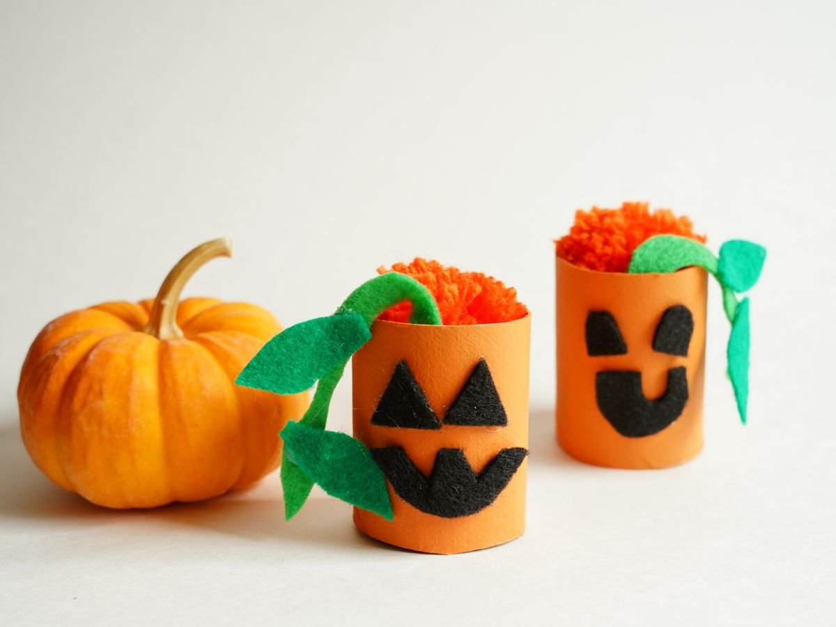 two toilet roll pumpkins on table with real pumpkin