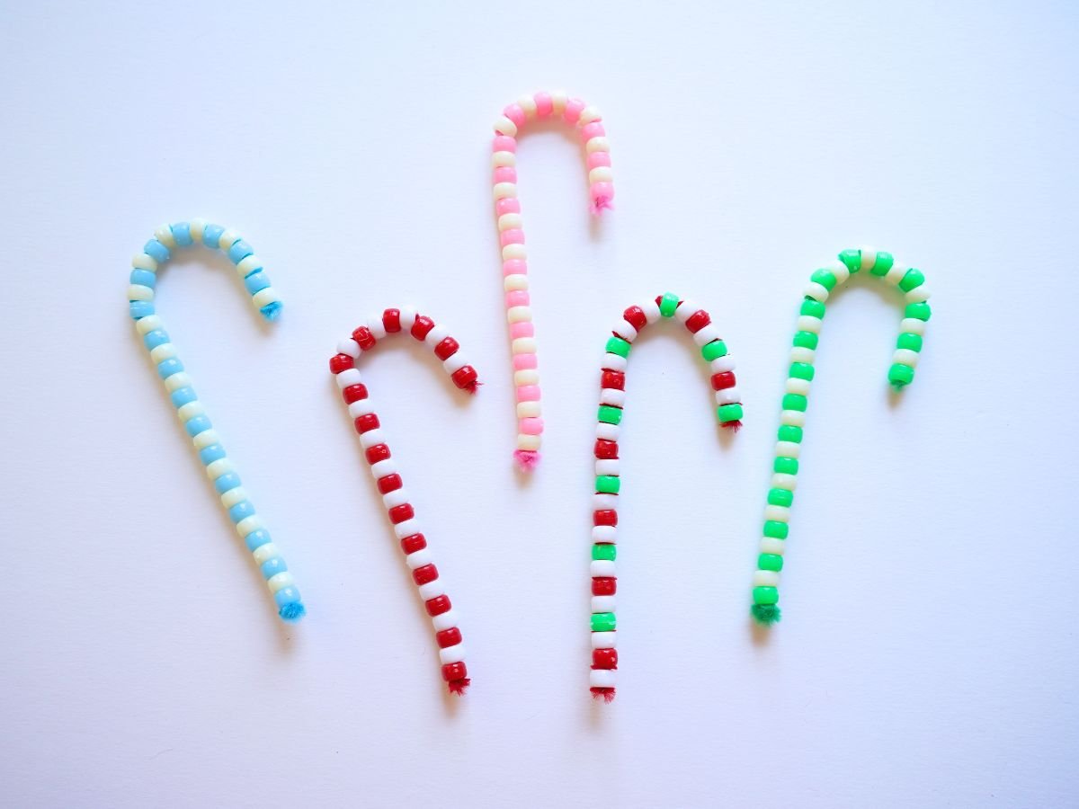 5 pipe cleaner beaded candy canes in different color combinations on table