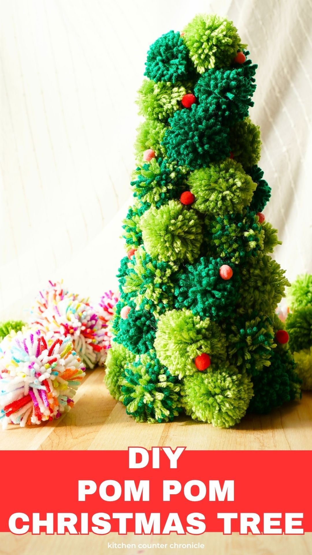 DIY pom pom Christmas tree craft sitting on table pin