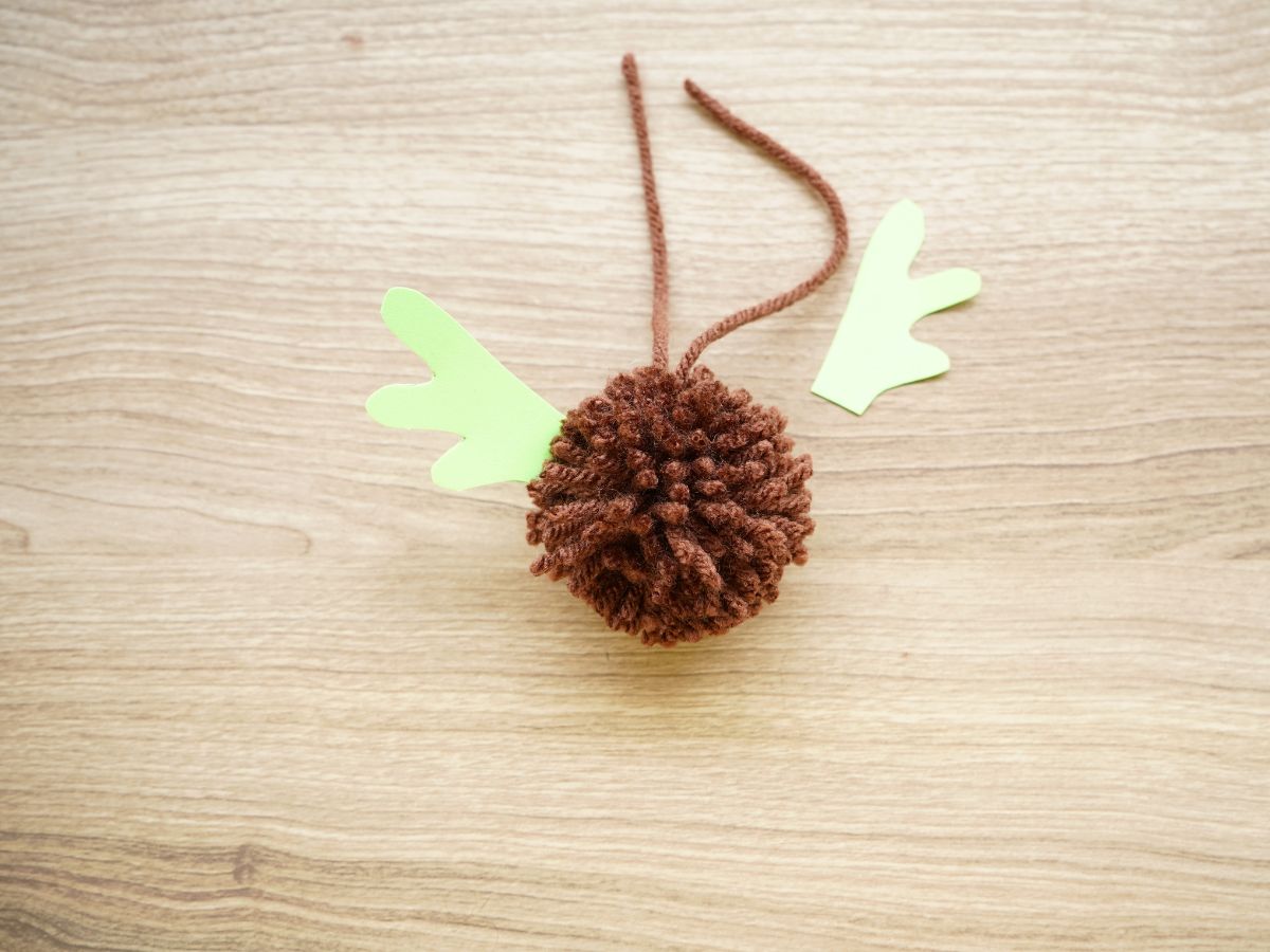 brown pom pom with paper reindeer antler glued in