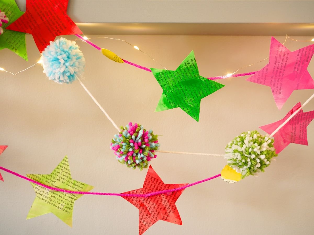 close up of diy book page paper star garland hanging on wall