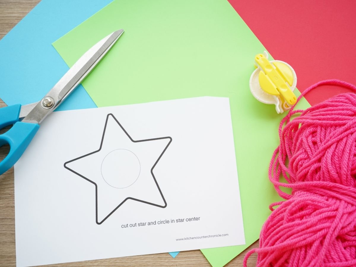 printable star ornament printed with scissors, yarn and pom pom maker