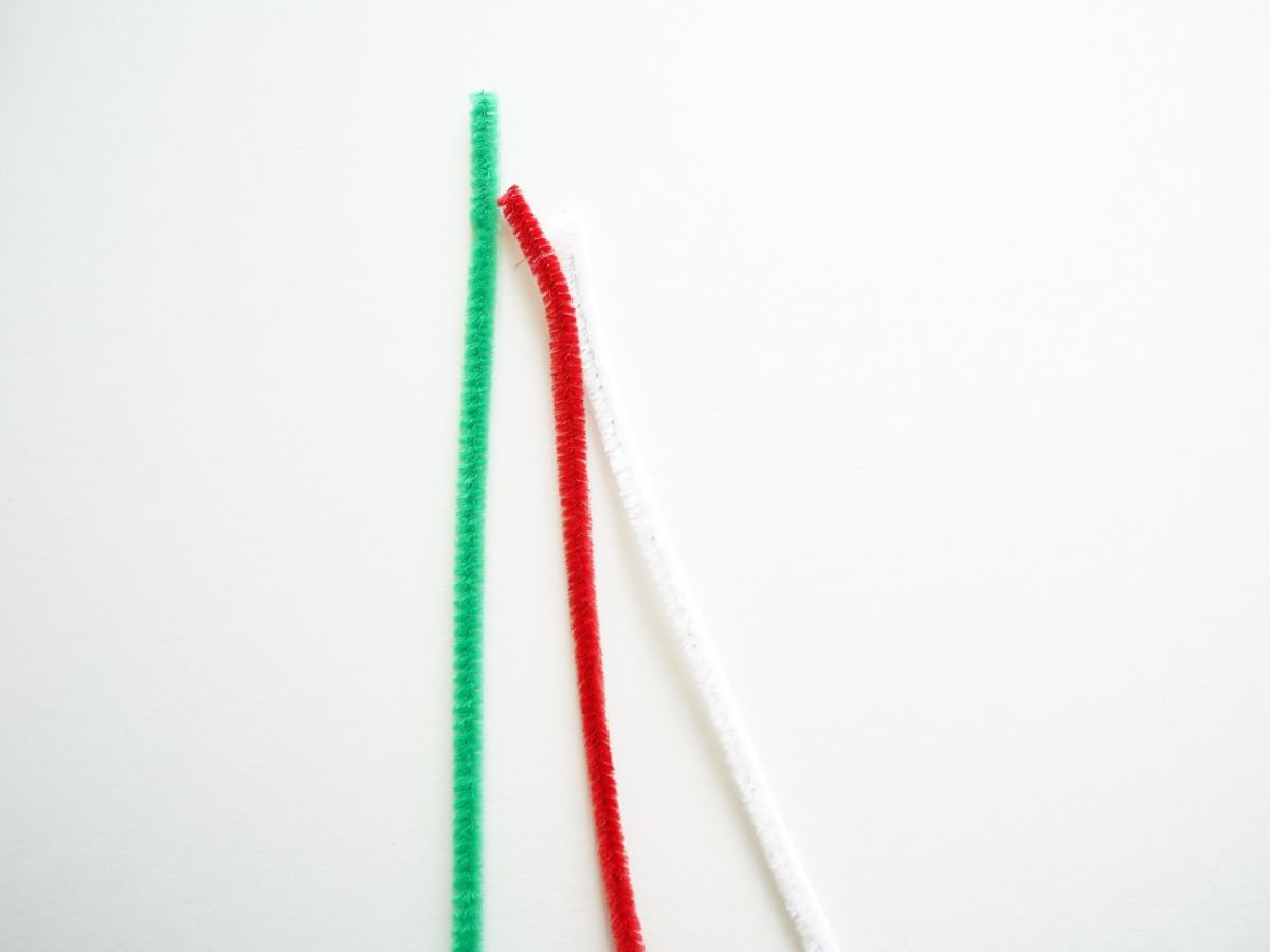 red, green, and white pipe cleaner on table