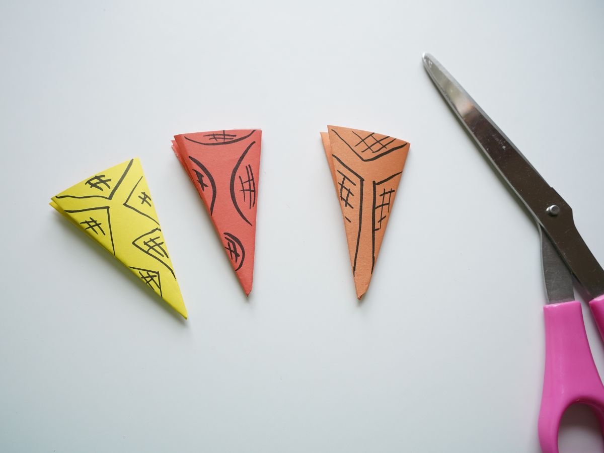 3 different examples of paper snowflake patterns to cut out with scissors